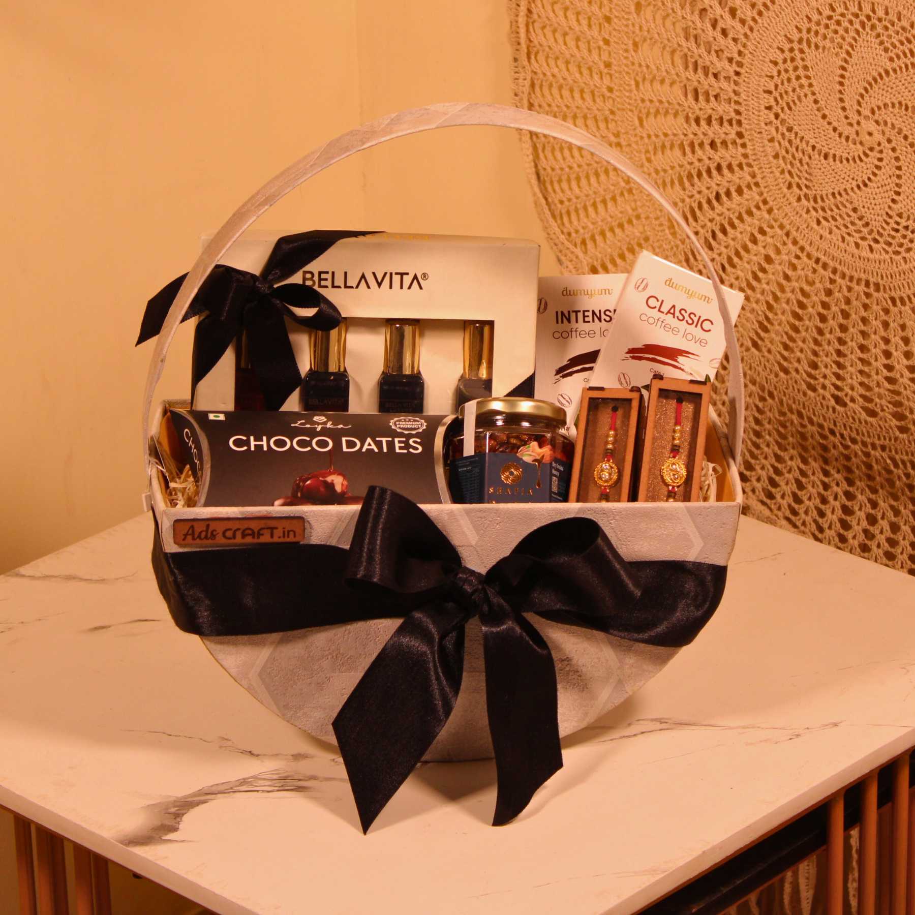 Premium Rakhi gift hamper for Bhaiya Bhabhi in a halfmoon decorative basket with black ribbon.

