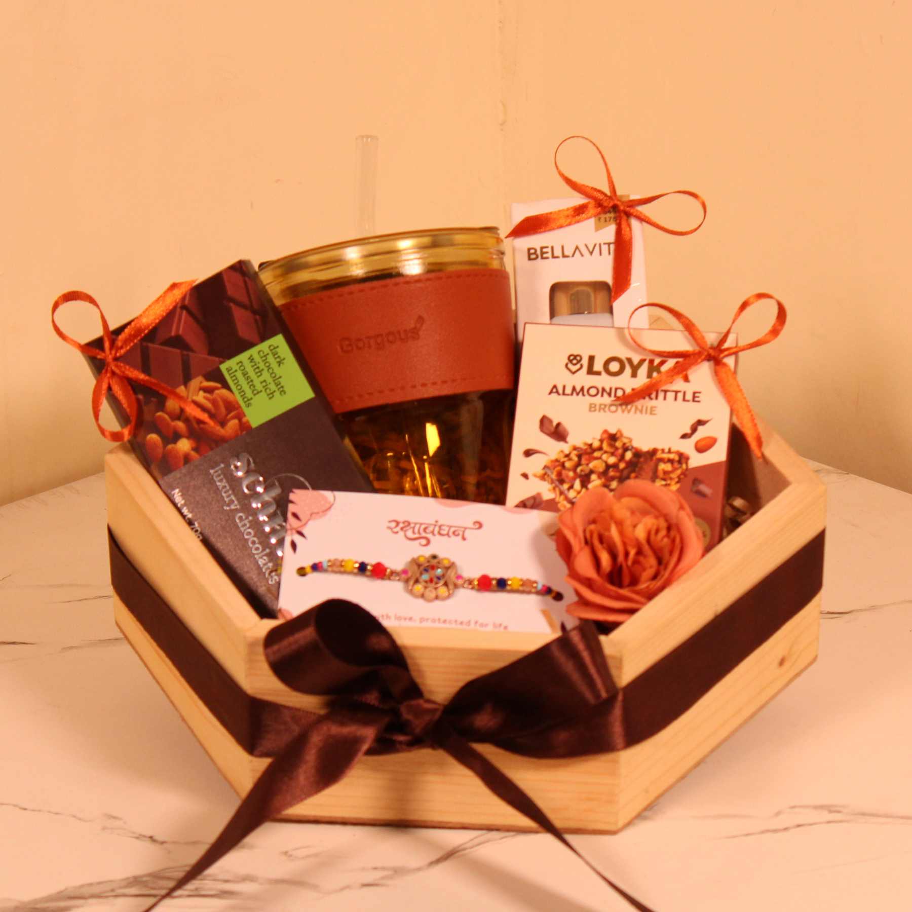 Premium Rakhi gift hamper for brother in a wooden hexagon basket with ribbon and luxury goodies