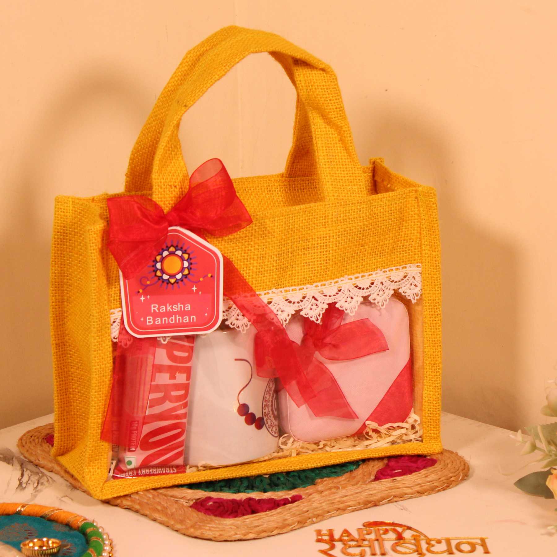 Rakhi Gift Hamper for Her – Yellow Jute Bag with Mug, Jewellery Organizer & Protein Bars