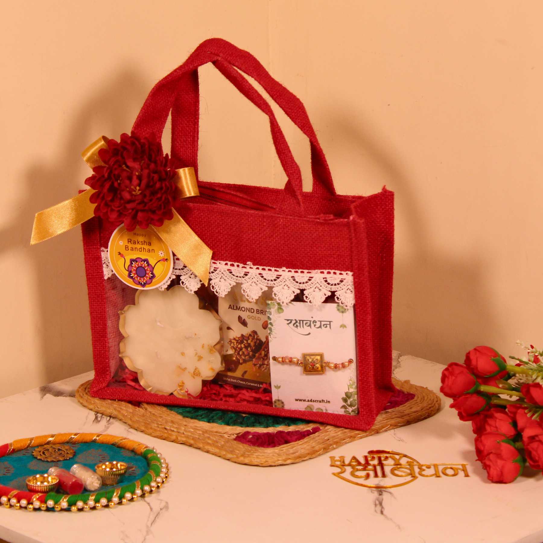 Rakhi Gift Hamper for Brother – Red Jute Bag with Party Mix, Scented Candle, Protein Bars & Rakhi