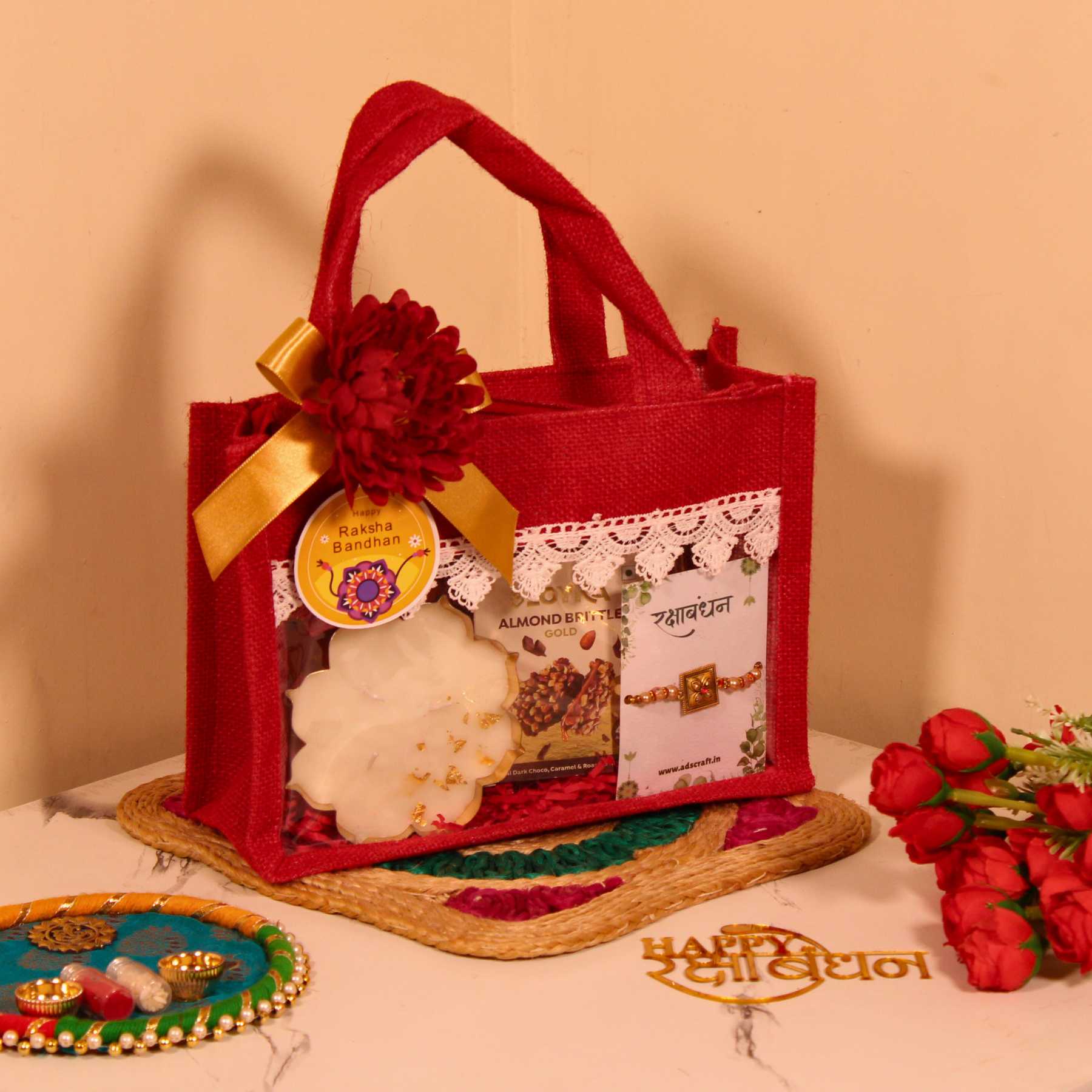 Rakhi Gift Hamper for Brother – Red Jute Bag with Party Mix, Scented Candle, Protein Bars & Rakhi