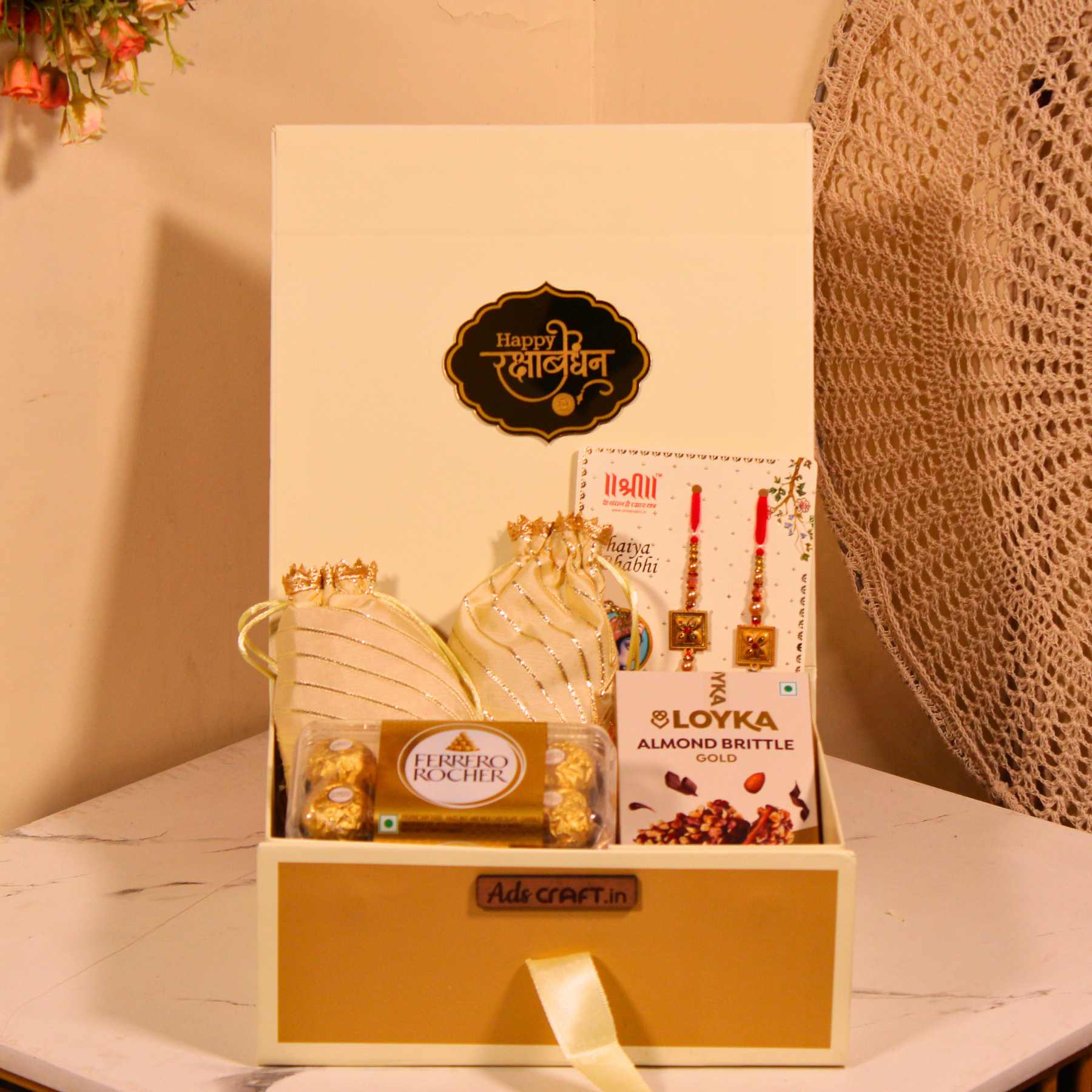 Rakhi gift hamper for Bhaiya Bhabhi in a cream collapsible box with couple rakhi, dry fruits, and Ferrero Rocher.