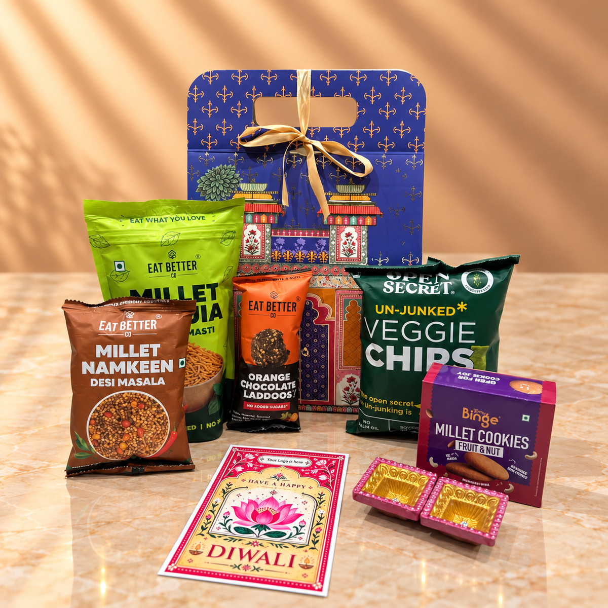 Blue Heritage Dome Diwali hamper with premium millet snacks, laddoos, cookies, decorative diyas and festive decor