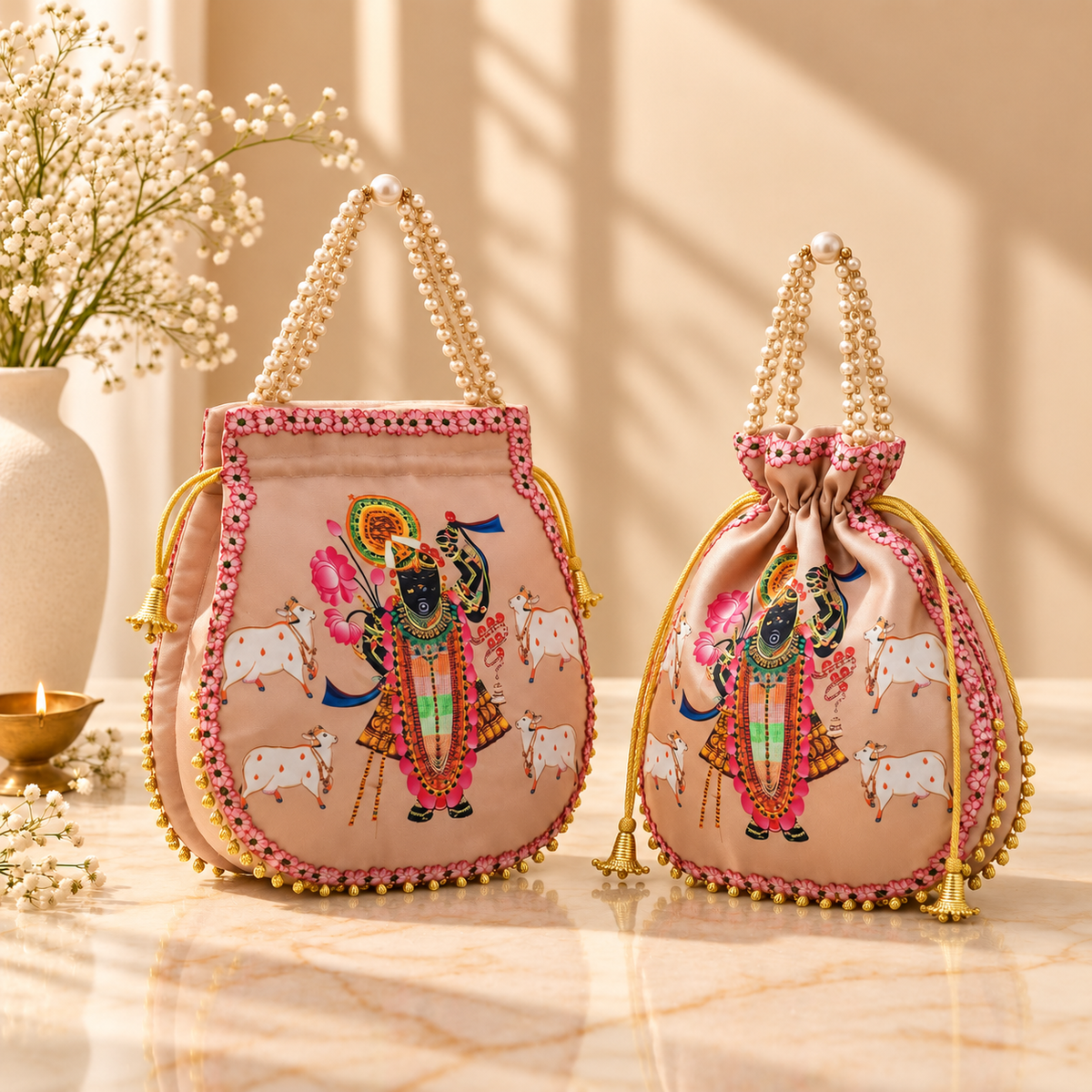 Handcrafted Shrinathji Pichwai satin potli bag with pearl bead handle for wedding and festive gifting in India