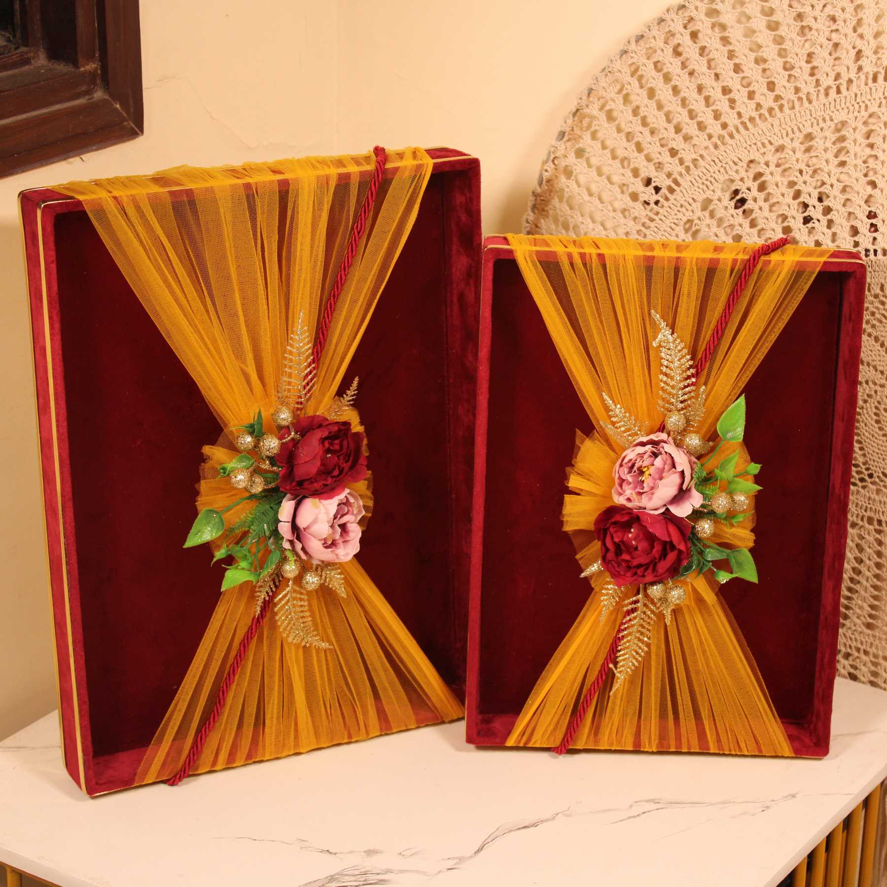 Indian wedding trousseau gift packing trays in maroon velvet with yellow net and artificial flower design