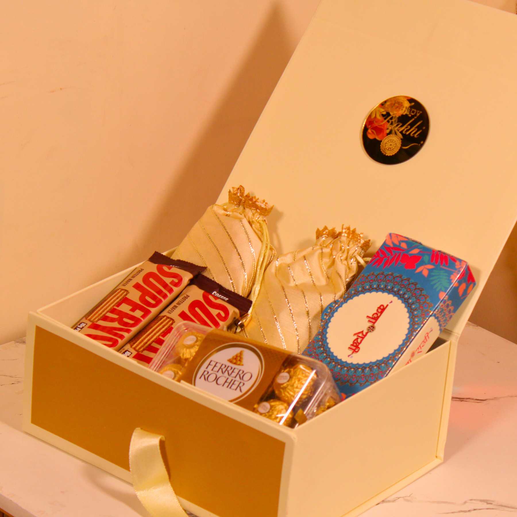 Raksha Bandhan hamper for bhai with potli dry fruits, premium chocolates, and festive card.