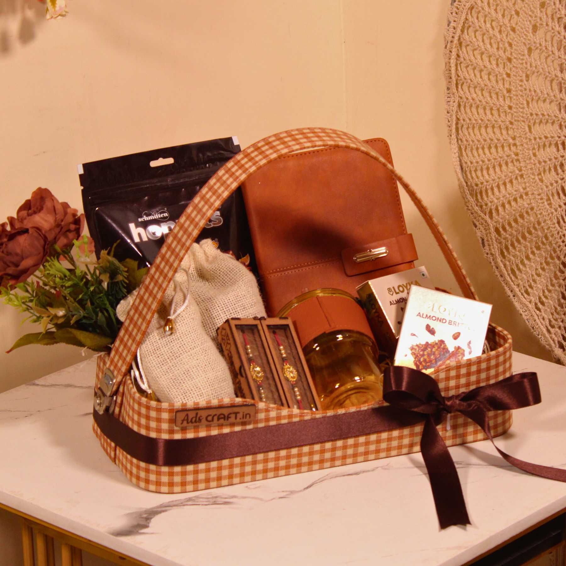 Rakhi gift hamper for brother in a brown check basket with dry fruits, Hoppits chocolate, and diary.
