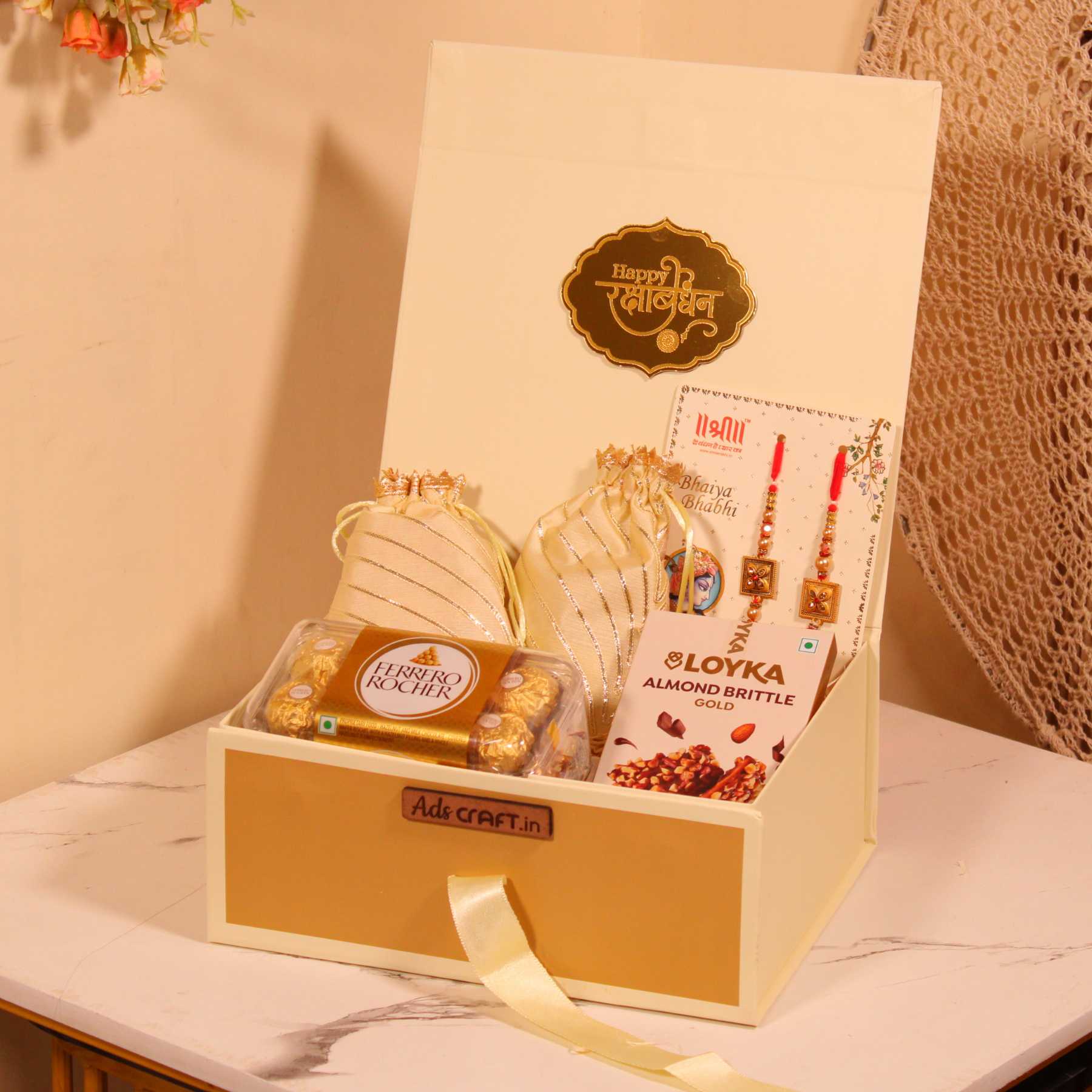 Rakhi gift hamper for Bhaiya Bhabhi in a cream collapsible box with couple rakhi, dry fruits, and Ferrero Rocher.