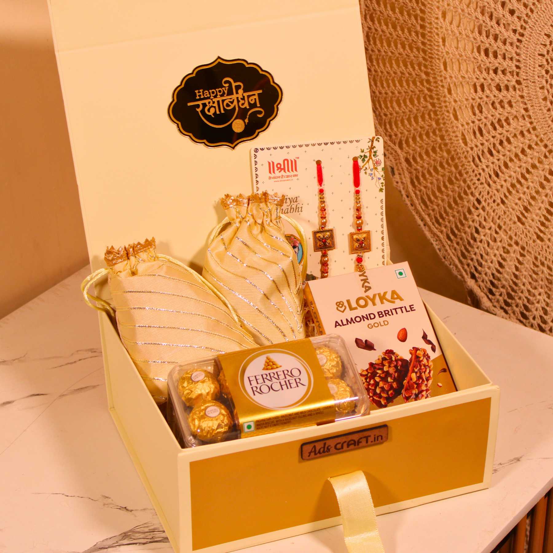 Rakhi gift hamper for Bhaiya Bhabhi in a cream collapsible box with couple rakhi, dry fruits, and Ferrero Rocher.