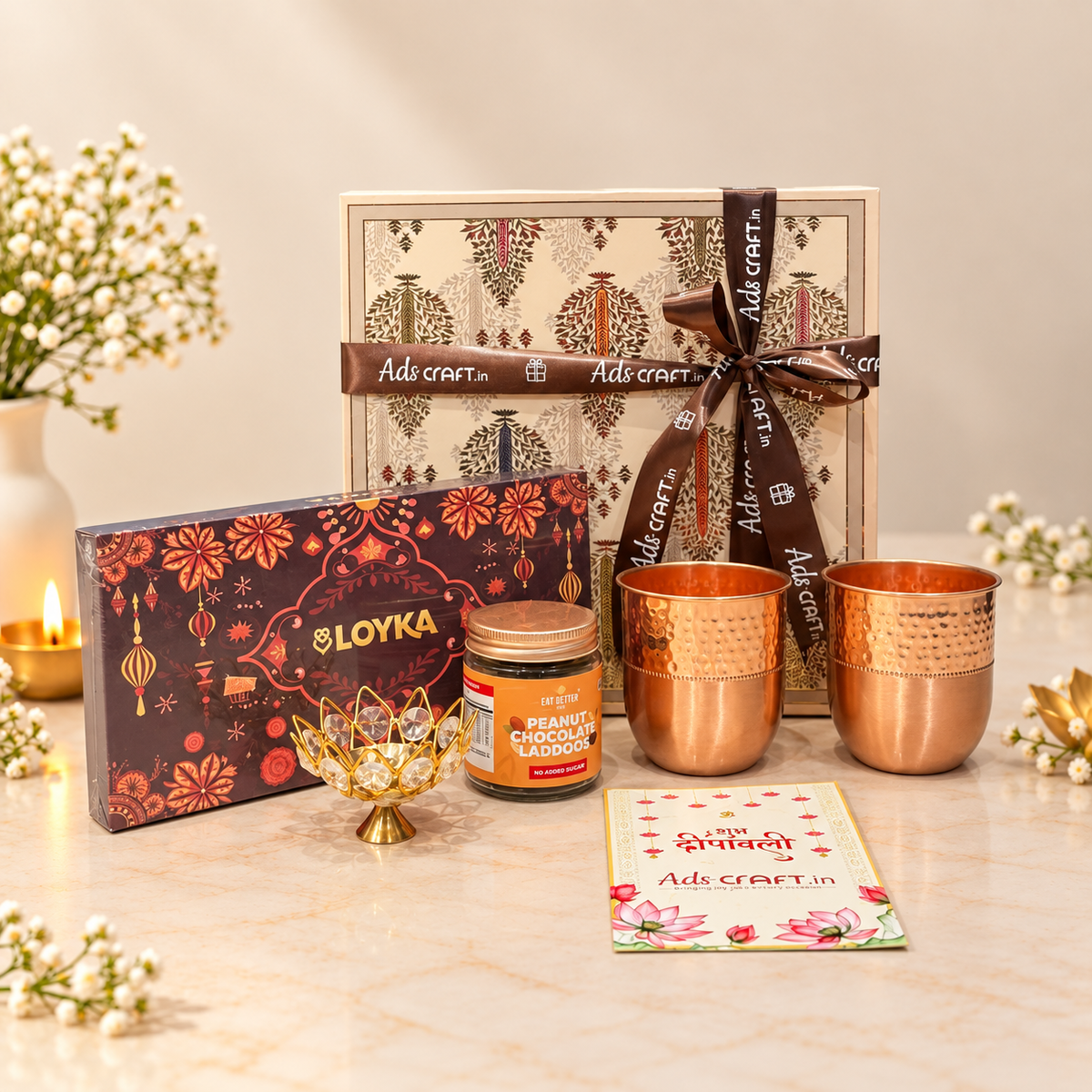 Copper Celebration Diwali hamper with two copper glasses, chocolate laddoo, Loyka brittle and copper crystal diya